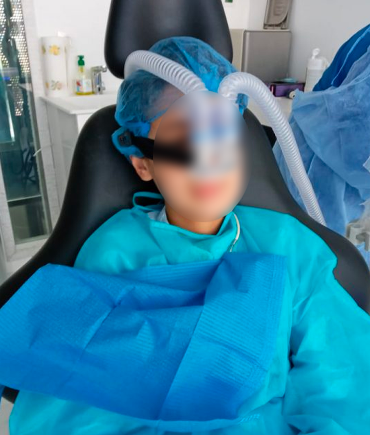 Jeune patient installé au fauteuil de soins dentaires.